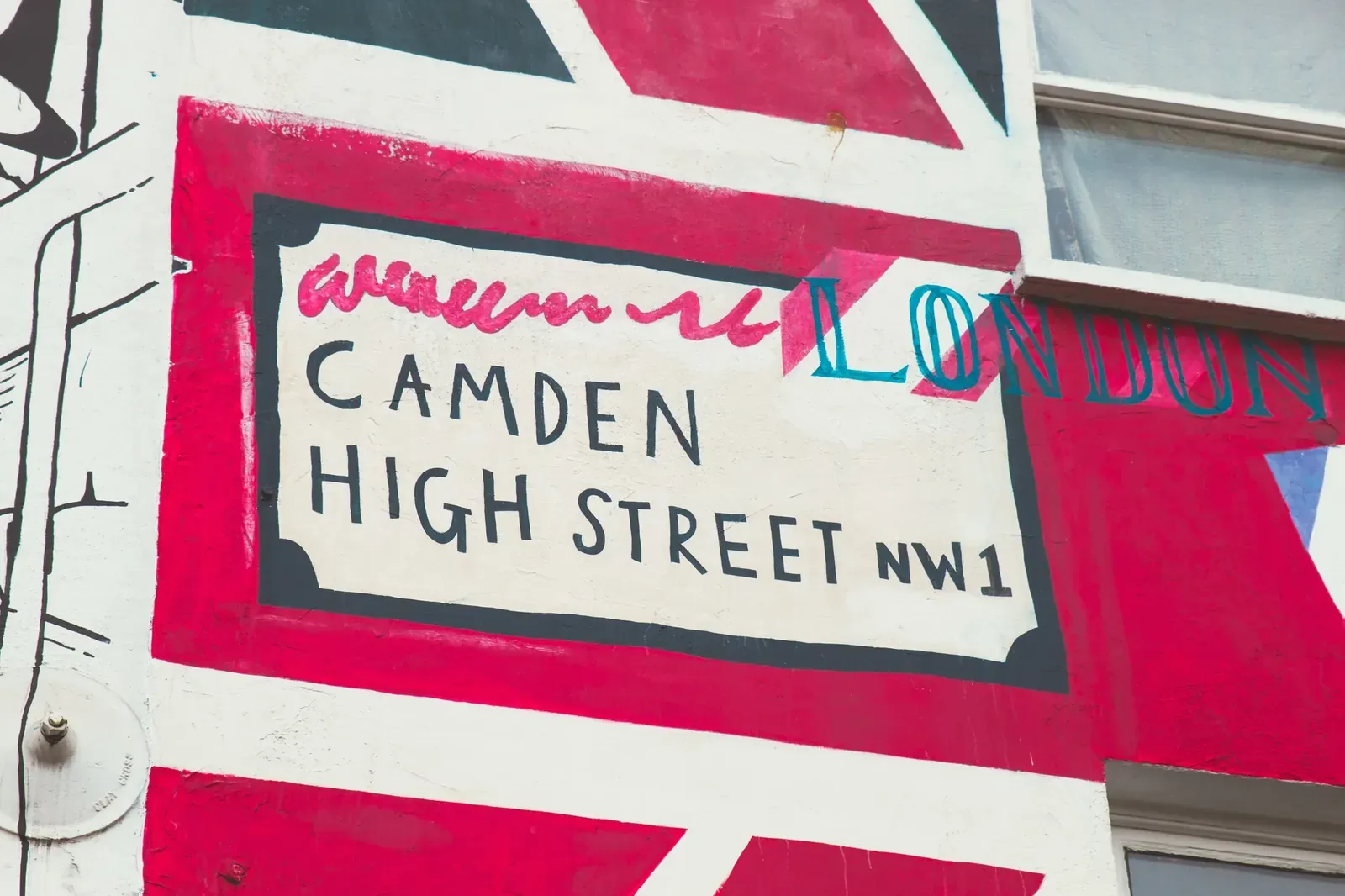 Camden High Street NW1 sign painted on a red and white wall