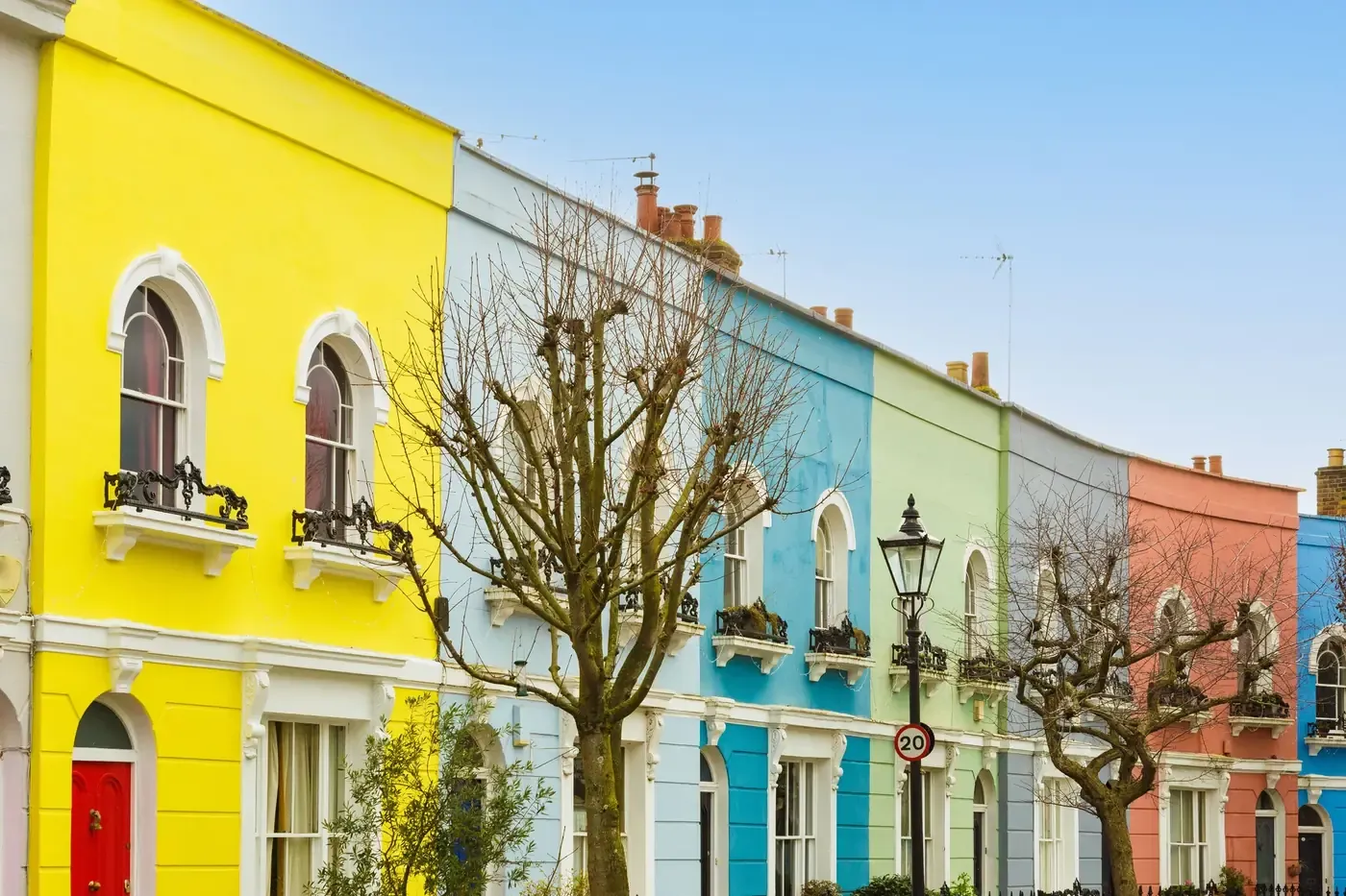 Row of terraced houses painted yellow, blue, green and orange