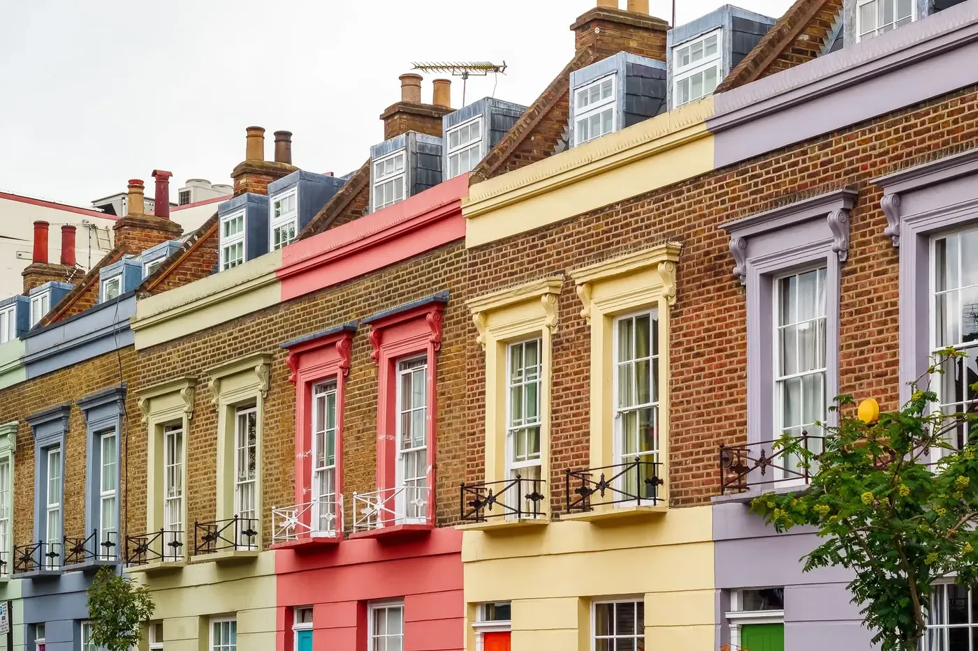 Brick terraced houses with painted window surrounds and ground floors in red, yellow and lilac